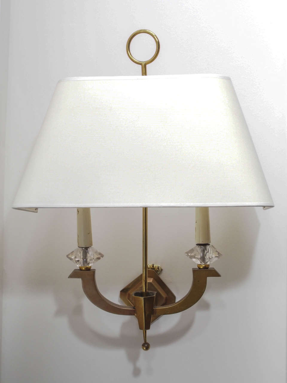 Single two-light sconce in gilt bronze; wooden tapers with faceted glass at the bases; half-shade in ivory silk.